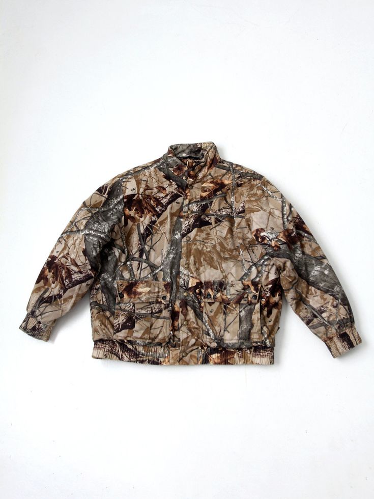 "This is a vintage Outfitters Ridge men's camo jacket.  Classic camouflage hunter's coat with snap button closure, big pleated snap pockets at the waist, and flannel lined interior.  CONDITION In good condition with wear consistent with age and use. Some piling to the ling.  MARKED SIZE: XL MEASUREMENTS Bust:  52\"  ...  132.1 cm Length:  29.25\"  ..  74.3 cm Shoulders:  21.5\"  ..  54.6 cm Outside Sleeve: 25\"  ..  63.5 cm 223228" Utility Outerwear For Hunting In Winter, Utility Outerwear For Winter Hunting, Utility Winter Hunting Outerwear, Winter Hunting Utility Outerwear, Khaki Utility Jacket For Hunting In Fall, Fall Hunting Khaki Outerwear, Winter Khaki Hunting Outerwear, Winter Khaki Outerwear For Hunting, Military Style Utility Jacket For Hunting In Fall