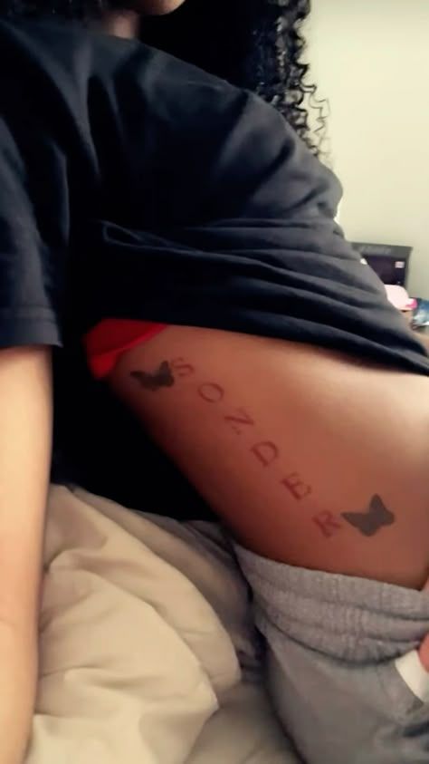 a woman laying on top of a bed with her stomach covered in words and arrows