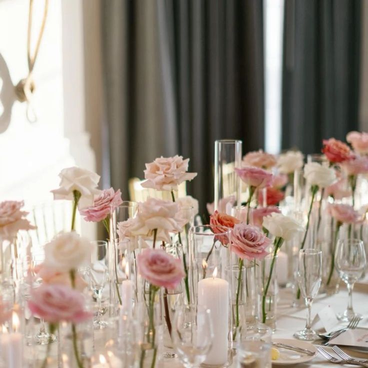 there are many vases with flowers in them on the table at this wedding reception