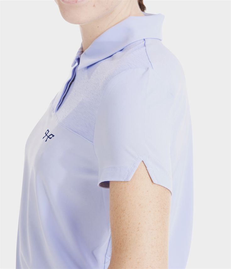 a woman wearing a polo shirt with an embellishment on the left side of her arm