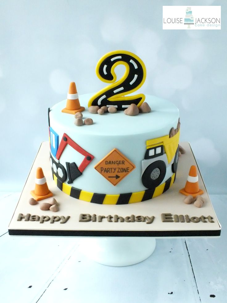 a birthday cake is decorated with construction equipment and the number 2 on it's side