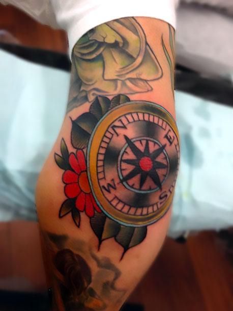 a man with a compass tattoo on his arm and leg is shown in black and white