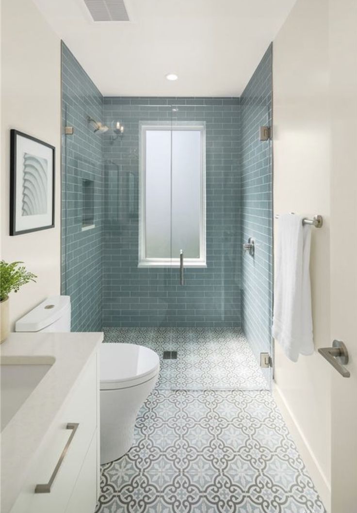 a bathroom with blue tile and white fixtures