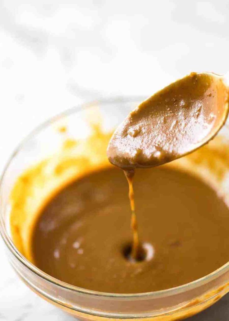 a spoon full of peanut butter being drizzled over