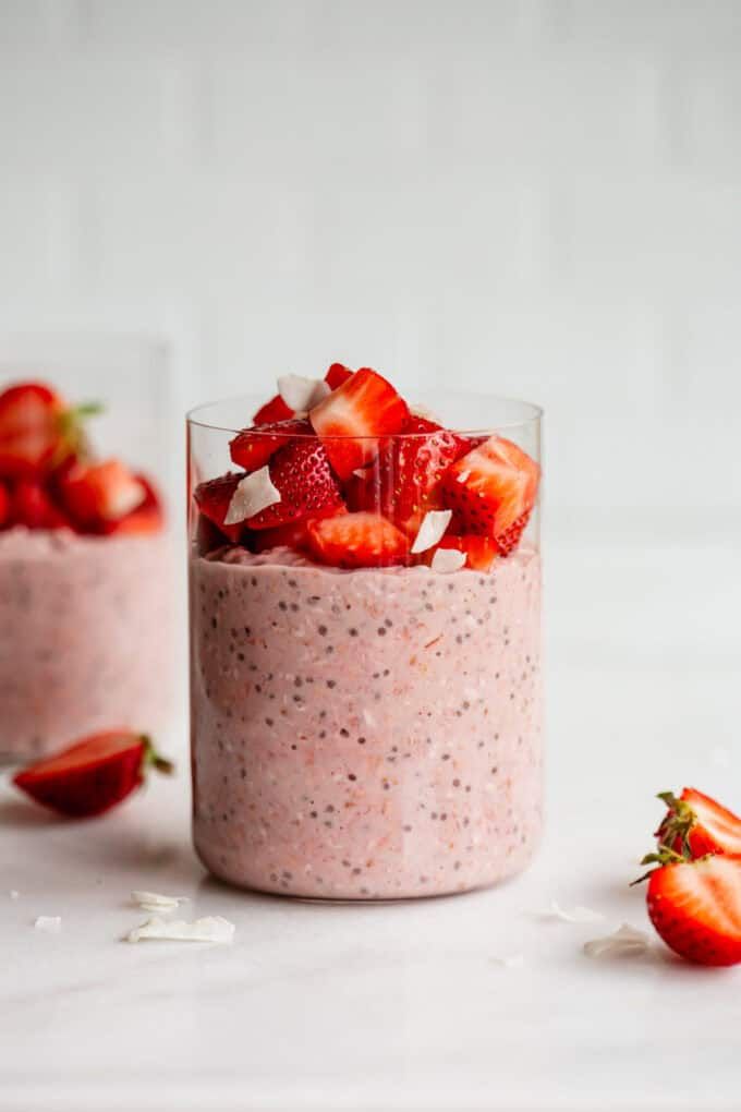 strawberry chia pudding in a glass with strawberries on the side