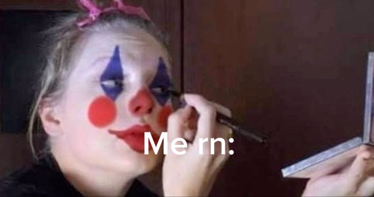 a woman with clown makeup is holding a mirror