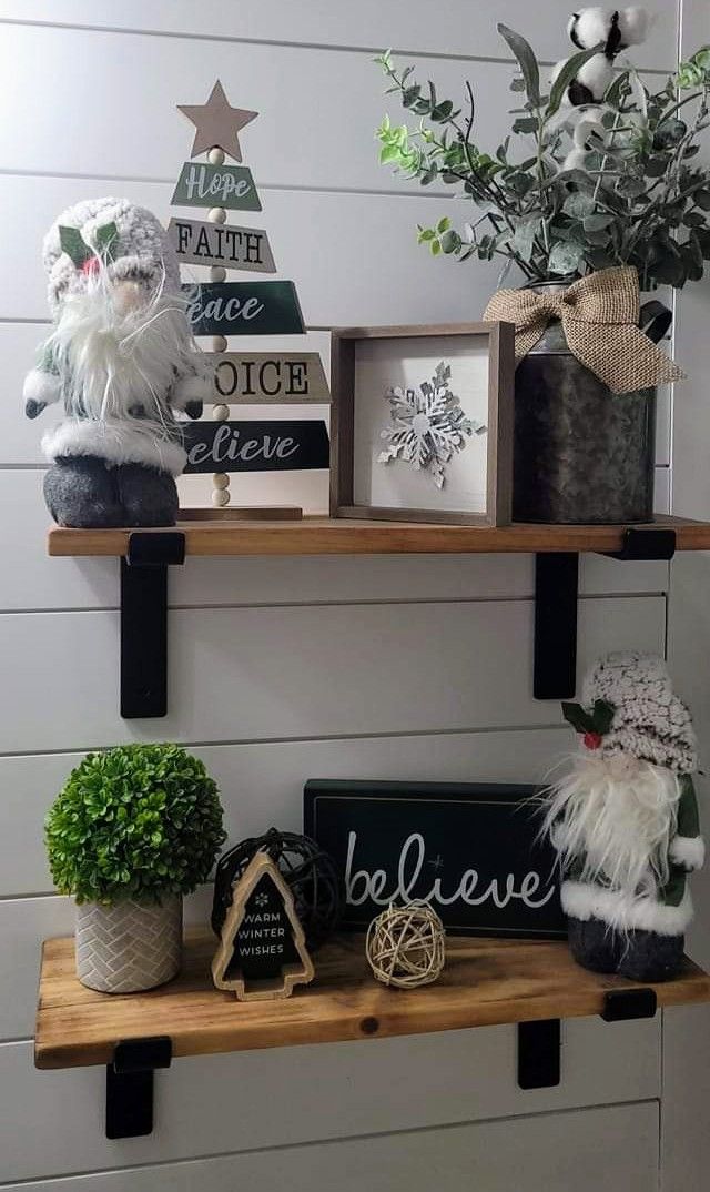 two shelves with christmas decorations on them and some plants in the middle one shelf is filled with ornaments