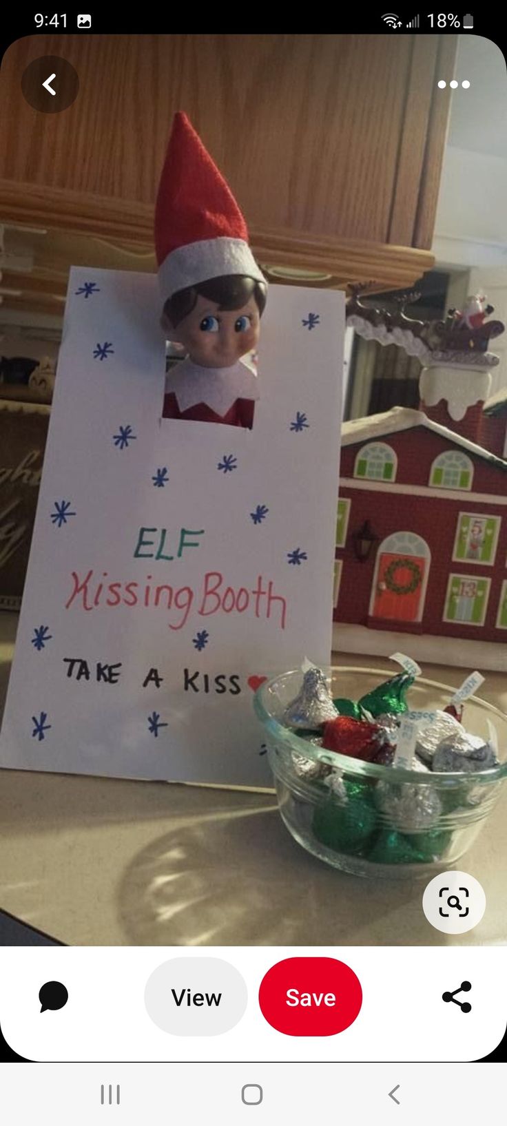 an elf holding a sign that says elf missing booth take a kiss on the lips