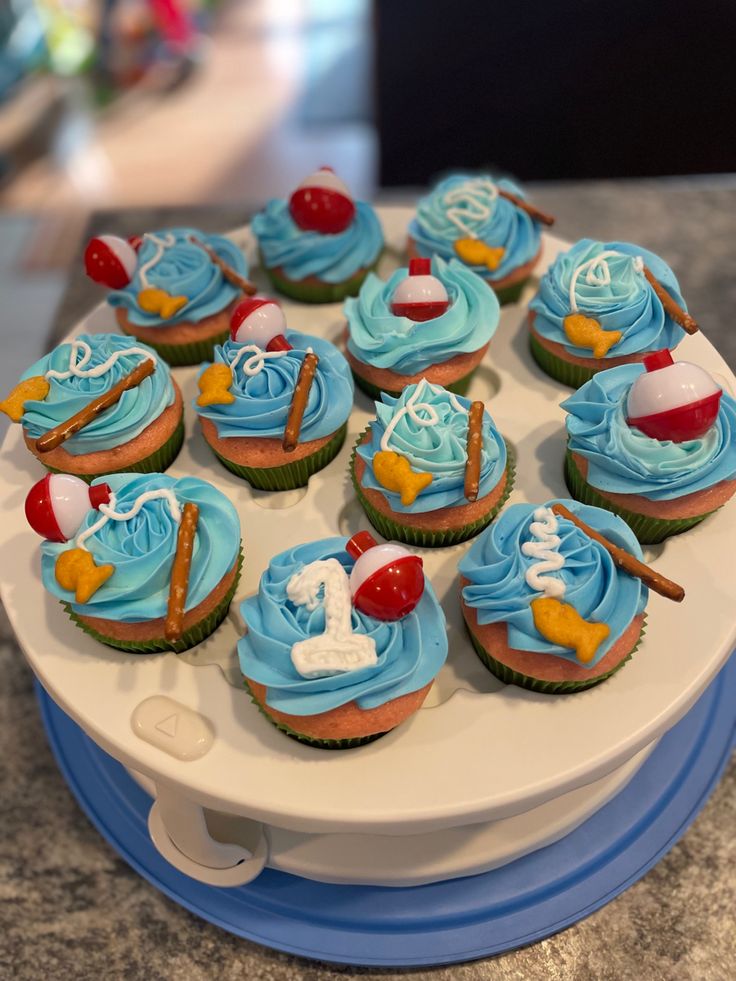 cupcakes with blue frosting are arranged on a platter