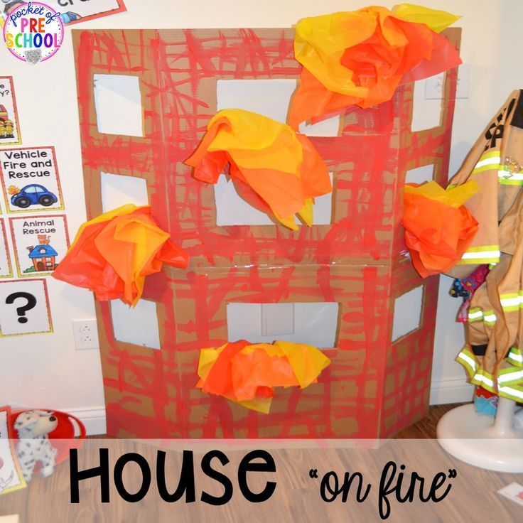 there is a cardboard house made to look like a fireman's house with orange and yellow paper on it