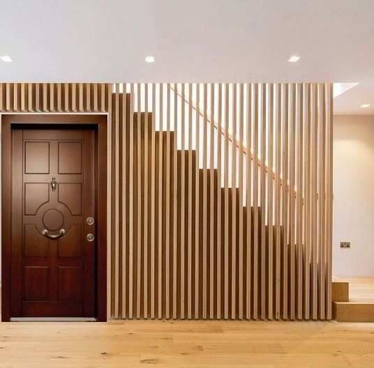 a wooden door in the middle of a room with stairs leading up to an entrance