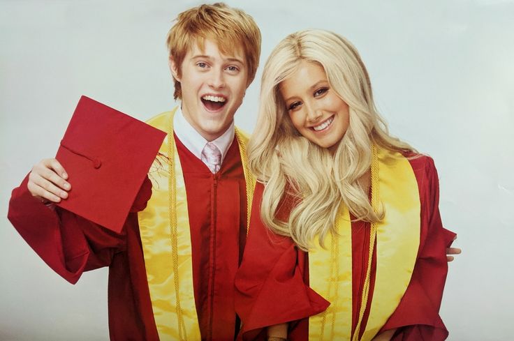 two people in graduation gowns posing for a photo