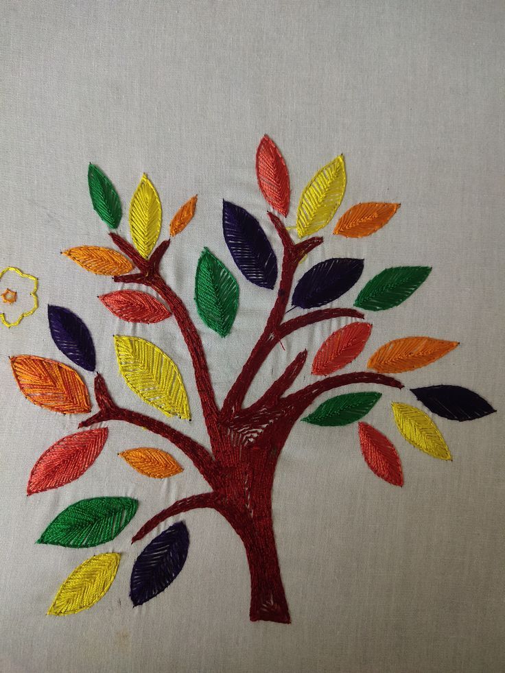 an embroidered tree with colorful leaves on it