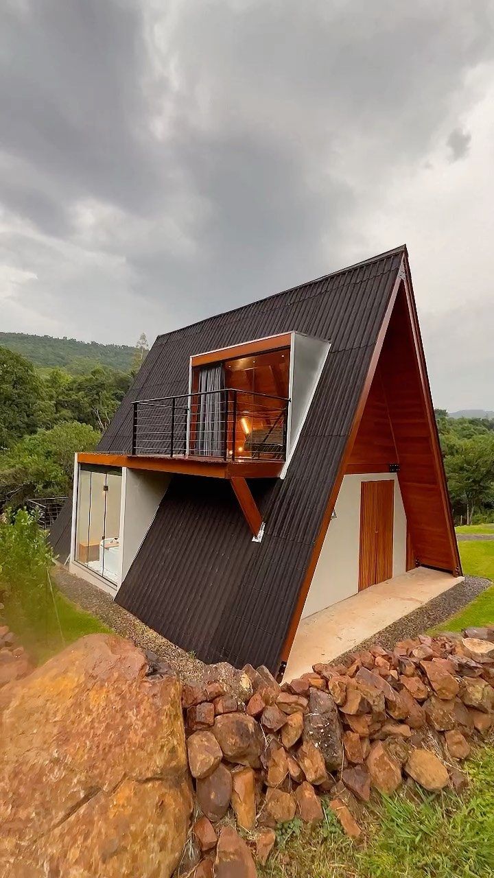 a small house with a roof made of wood and metal on top of a hill