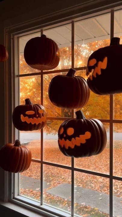 pumpkins are hanging from the windowsill for halloween