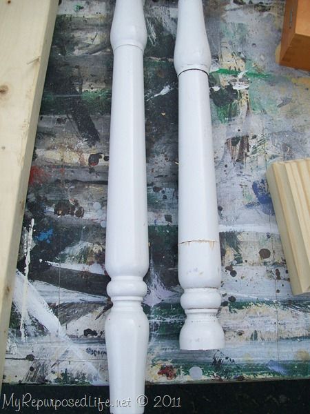 two white wooden posts sitting next to each other on top of a painting covered ground