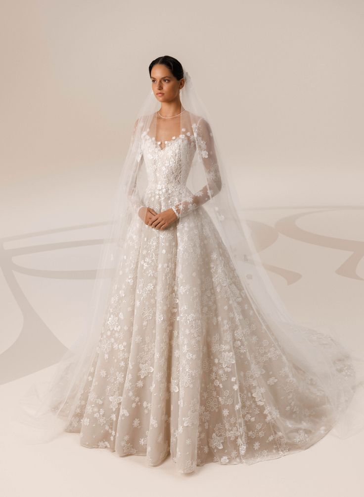 a woman in a wedding dress with a veil on her head, standing against a white background