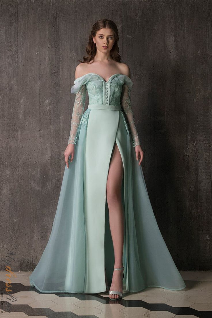 This stunning Chrystelle Atallah Muse M02 Aqua dress is made of luxurious crepe silk, with a crin and tulle couture overskirt. It's adorned with beautiful encrusted chantilly lace, beads and embellishments on the bodice and sleeves. The organza silk material work on the neckline and shoulders adds an elegant touch. The skirt has a slit for added style, and the belt detail completes the look. Tulle Couture, Carpet Outfits, Matric Dance, Defined Waist, Exquisite Gowns, Winter Dress Outfits, Fantasy Gowns, Aqua Dress, Fantasy Dress