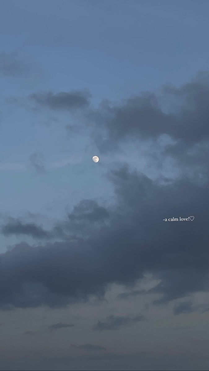 the moon is seen through some dark clouds