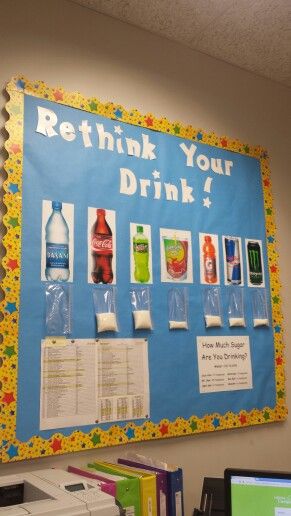 an office desk with a sign on the wall that says rethink your drink