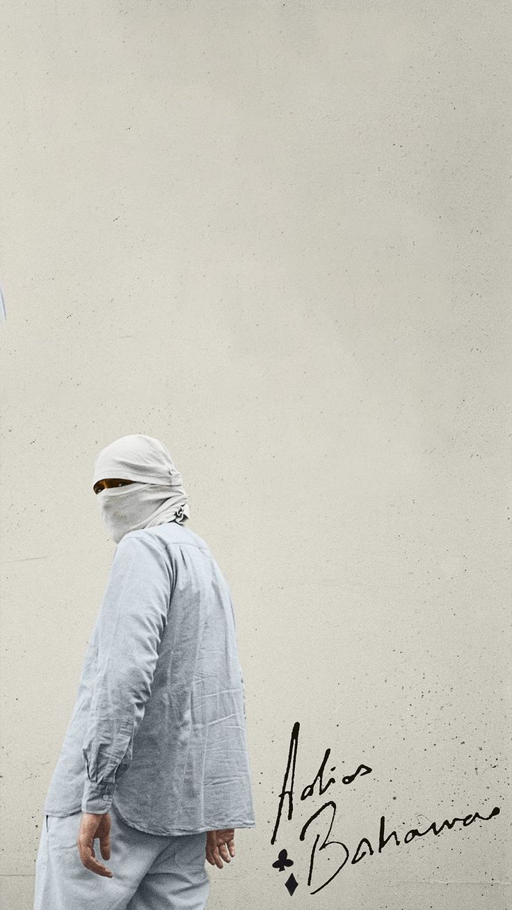 a man walking down the street in front of a wall with an umbrella on it