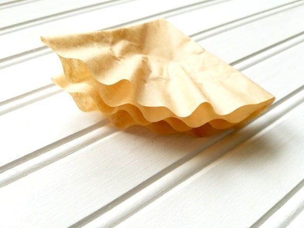 an empty paper plate sitting on top of a white wooden table with horizontal lines in the background