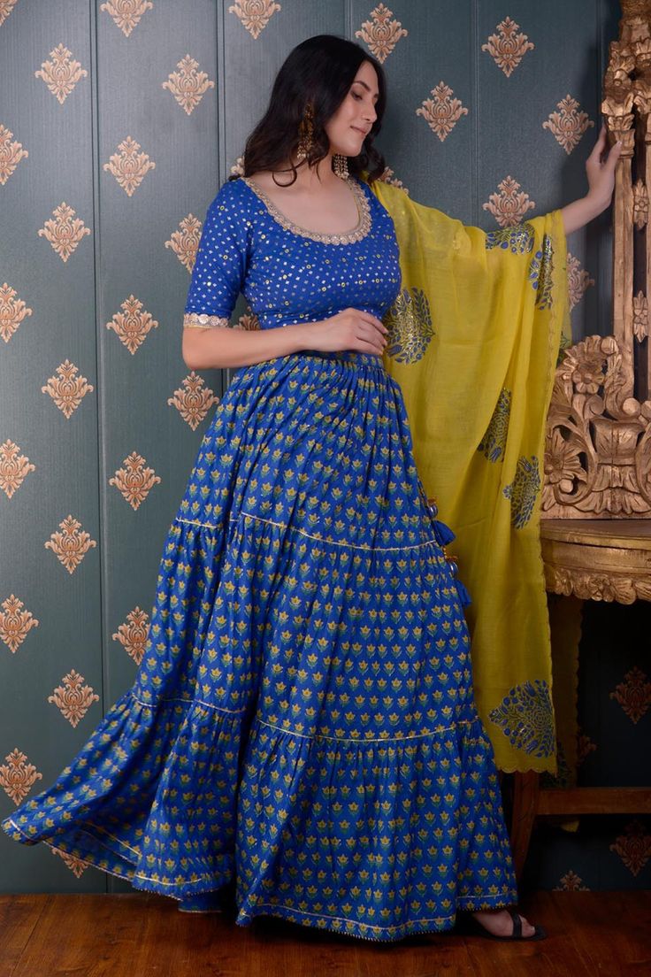 Royal blue tiered lehenga with floral block print motifs and gota patti trim on the hem. Comes with mirror embroidered blouse and lemon yellow floral print dupatta.
Component: 3
Pattern: Print and Embroidery
Type Of Work: Block Print and Mirror
Neckline: Round
Sleeve Type: Half
Fabric: Lehenga: Cotton Silk, Blouse: Banarasi Chanderi and Dupatta: Chanderi
Color: Blue
Other Details: 
Printed dupatta with scalloped border
Tie up with tassels on the side
Lace trim on the neckline and sleeve hems
Low Traditional Drape Sharara With Block Print For Festivals, Block Print Palazzo Set For Wedding And Festivals, Traditional Drape Block Print Sharara For Festivals, Bollywood Style Block Print Sharara For Navratri, Wedding Palazzo Set With Block Print For Festivals, Traditional Drape Sharara With Block Print For Diwali, Block Print Palazzo Set For Diwali Wedding, Designer Festival Sharara With Block Print, Block Print Palazzo Set For Wedding And Diwali