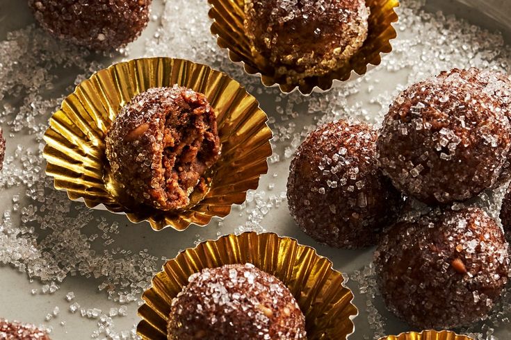 chocolate desserts with powdered sugar on top in gold foil wrappers and sprinkles