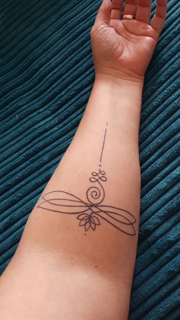 a woman's arm with a tattoo on it that has a ribbon and flower