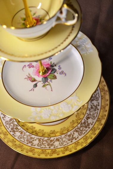 a stack of yellow and white plates with pink flowers on them sitting on a table