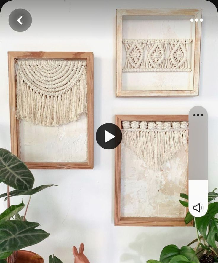 three framed pictures hanging on the wall next to plants