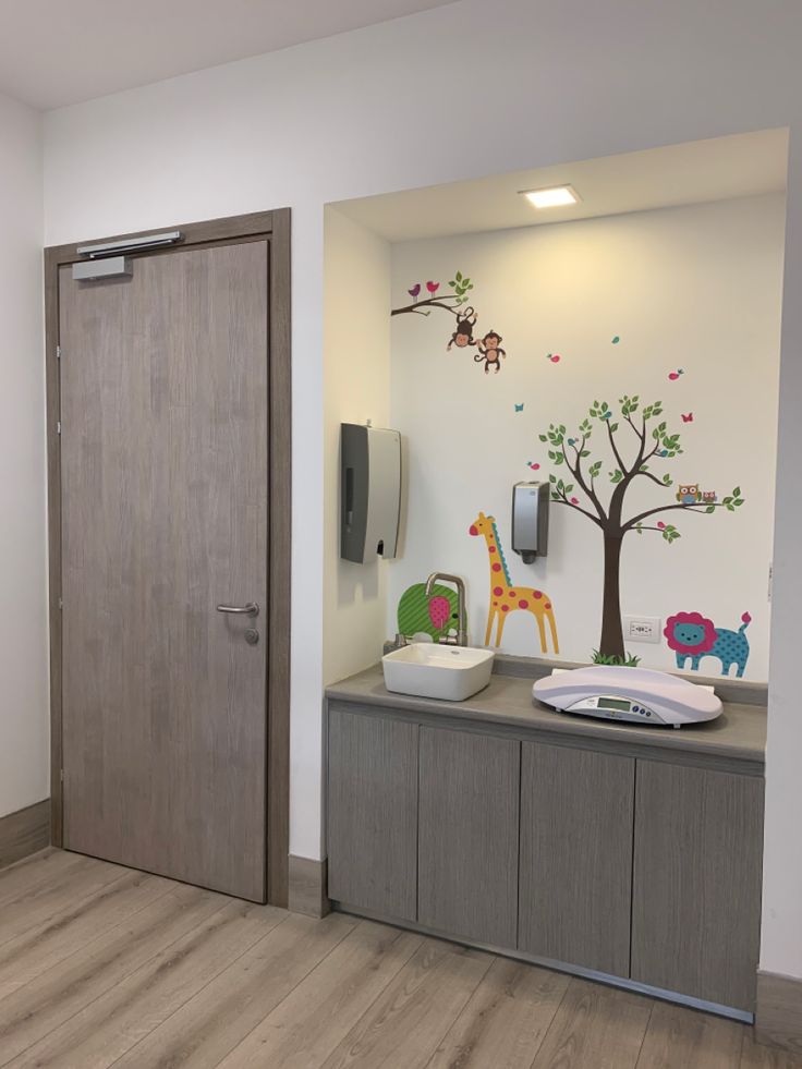 a baby's playroom with wooden floors and wall art on the walls,