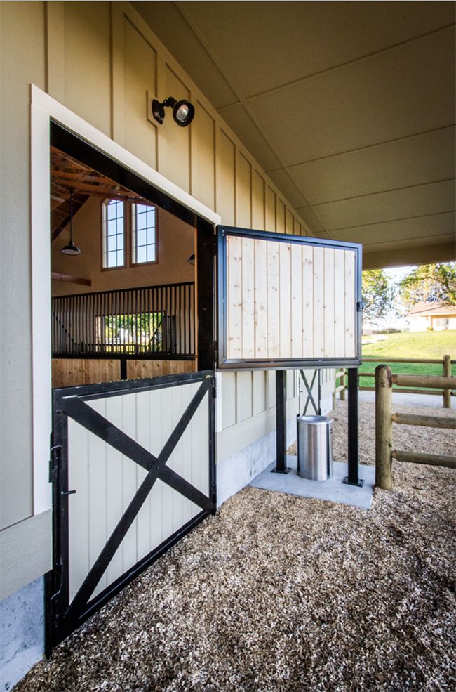 an open door to a stable with a horse in the background