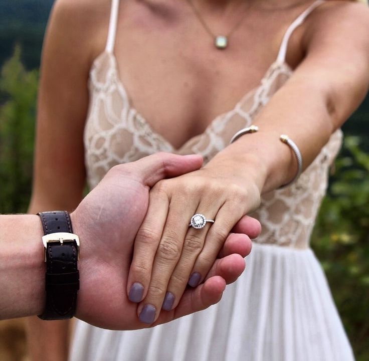 a man and woman holding hands while standing next to each other