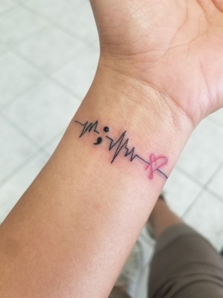 a woman's wrist with a heartbeat tattoo on it