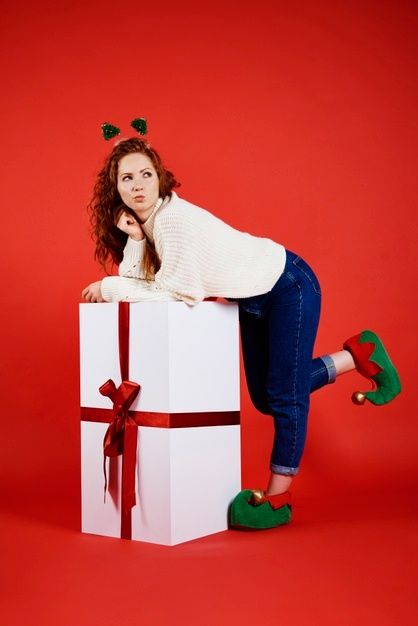 a woman sitting on top of a white present box