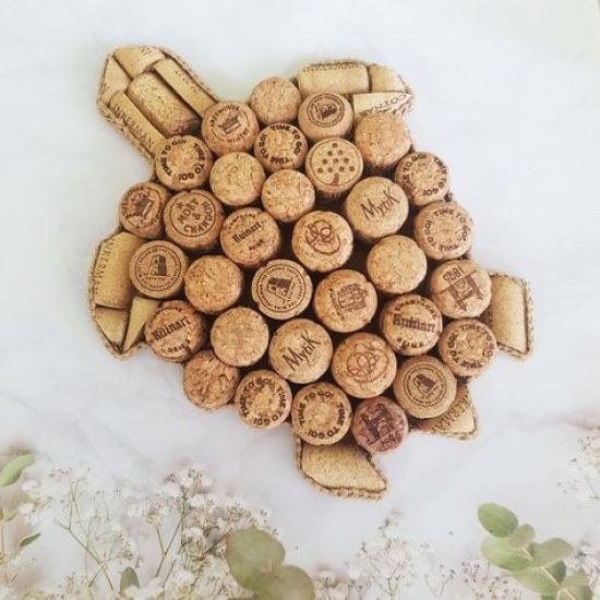 a bunch of wine corks are arranged in the shape of a fish on a white surface