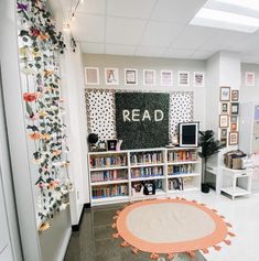 a room with many bookshelves and pictures on the wall, including a round rug