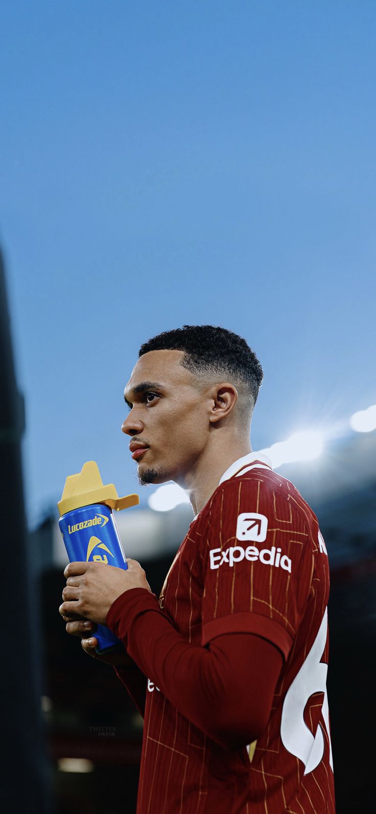 a young man holding a blue and yellow object in his hand while wearing a red shirt