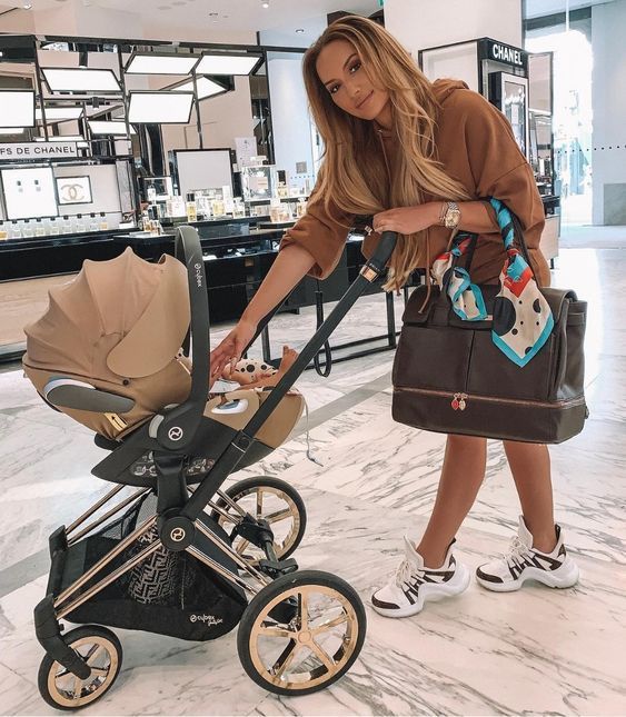 a woman standing next to a baby stroller