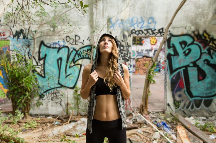 a woman standing in front of graffiti covered walls