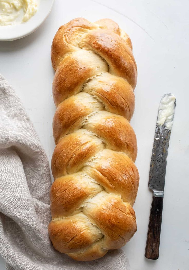 a loaf of bread sitting on top of a table next to a knife and bowl