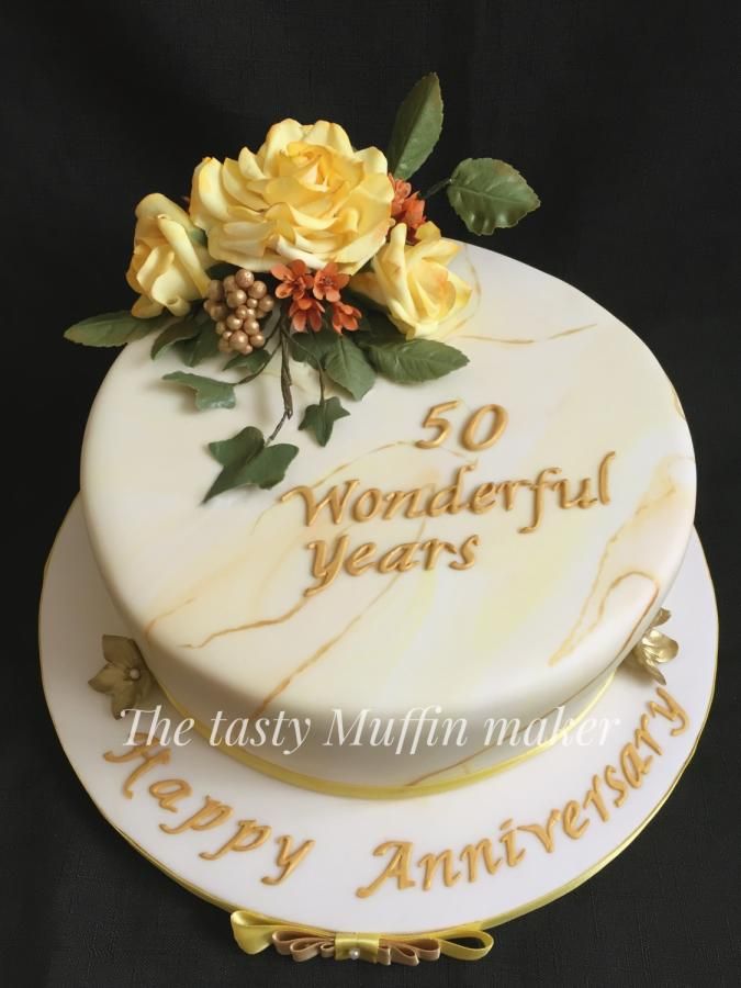 a 50th birthday cake decorated with flowers and the words wonderful years on it's side