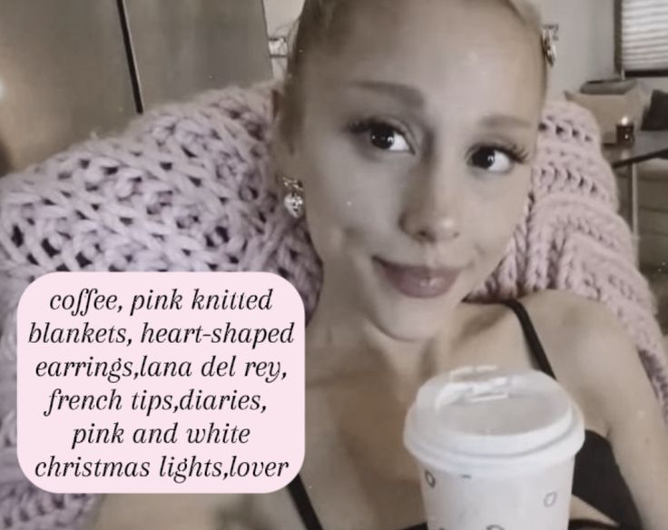 a woman is holding a coffee cup and looking at the camera with a caption that reads, coffee, pink knitted blankets, hear - shaped earrings, heart - shaped earrings,