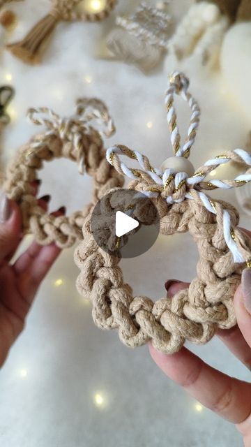 someone is holding up a small ornament made out of rope and wood beads