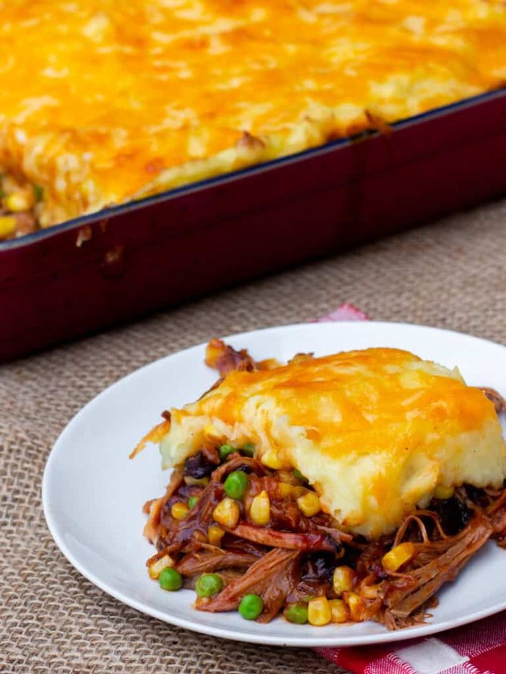 a white plate topped with food next to a casserole dish