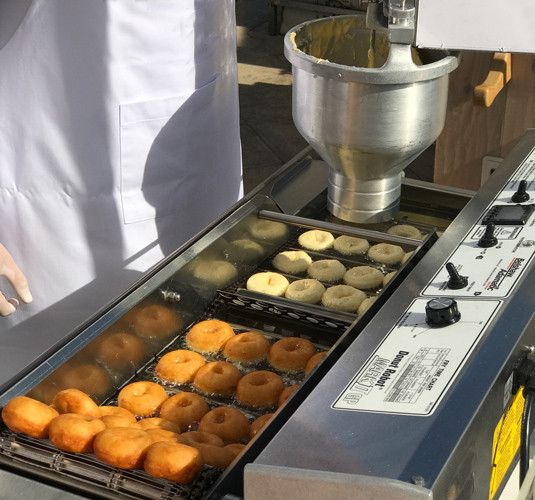 doughnuts being made on a conveyor belt