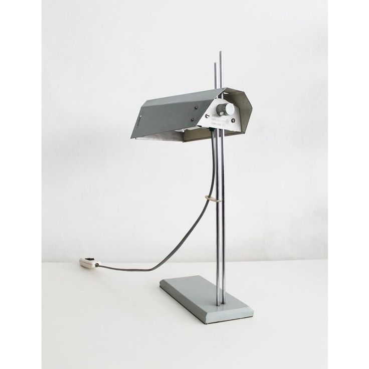 a desk lamp that is on top of a white surface with a cord attached to it