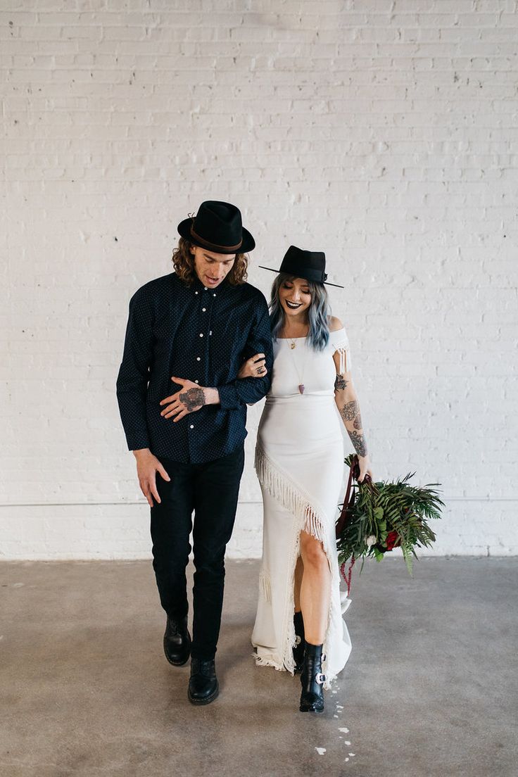 a man and woman dressed in black standing next to each other