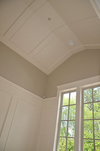 an empty room with two windows and no curtains on the ceiling, in front of trees